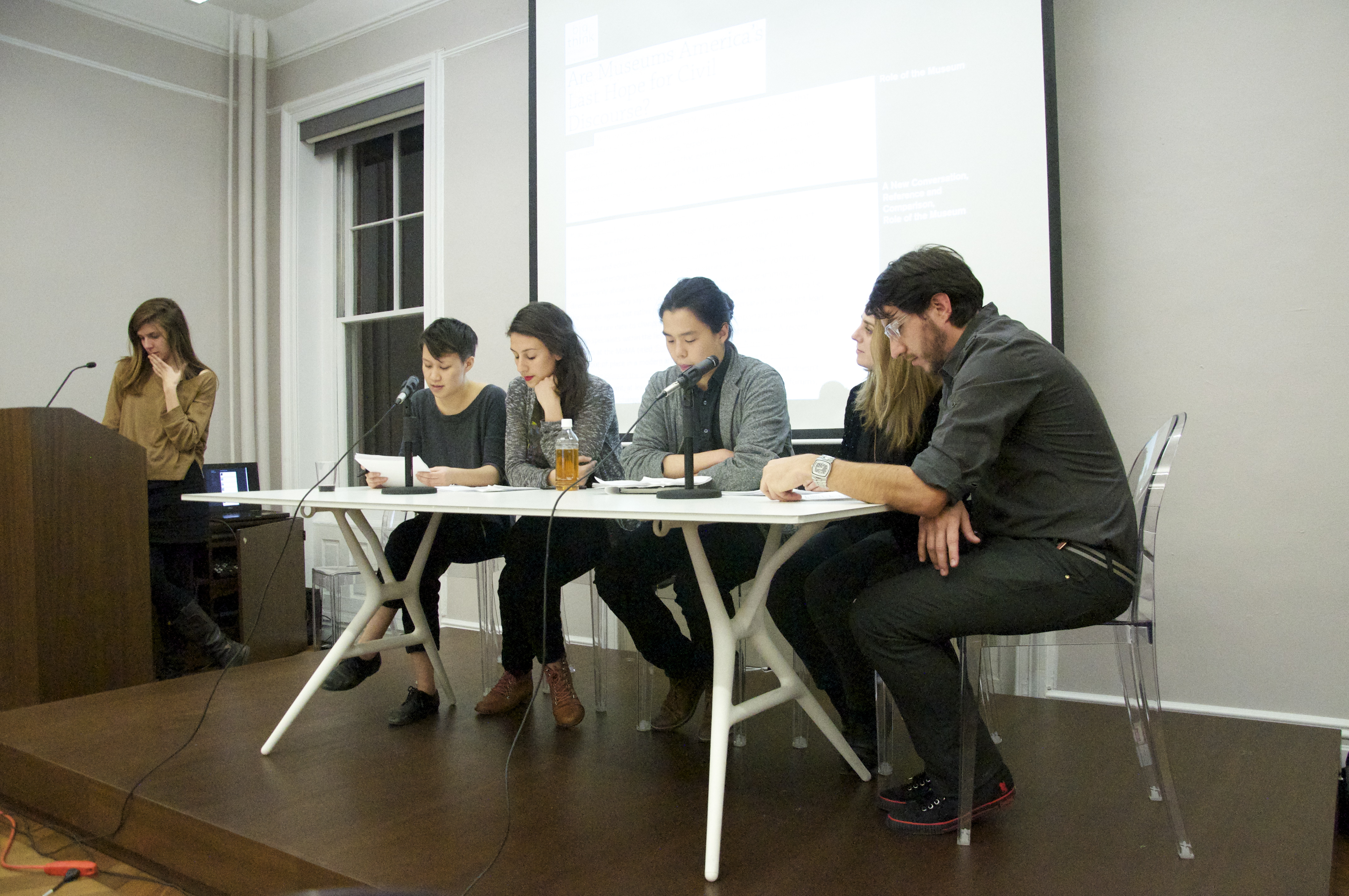 Five people seated on a stage at a table