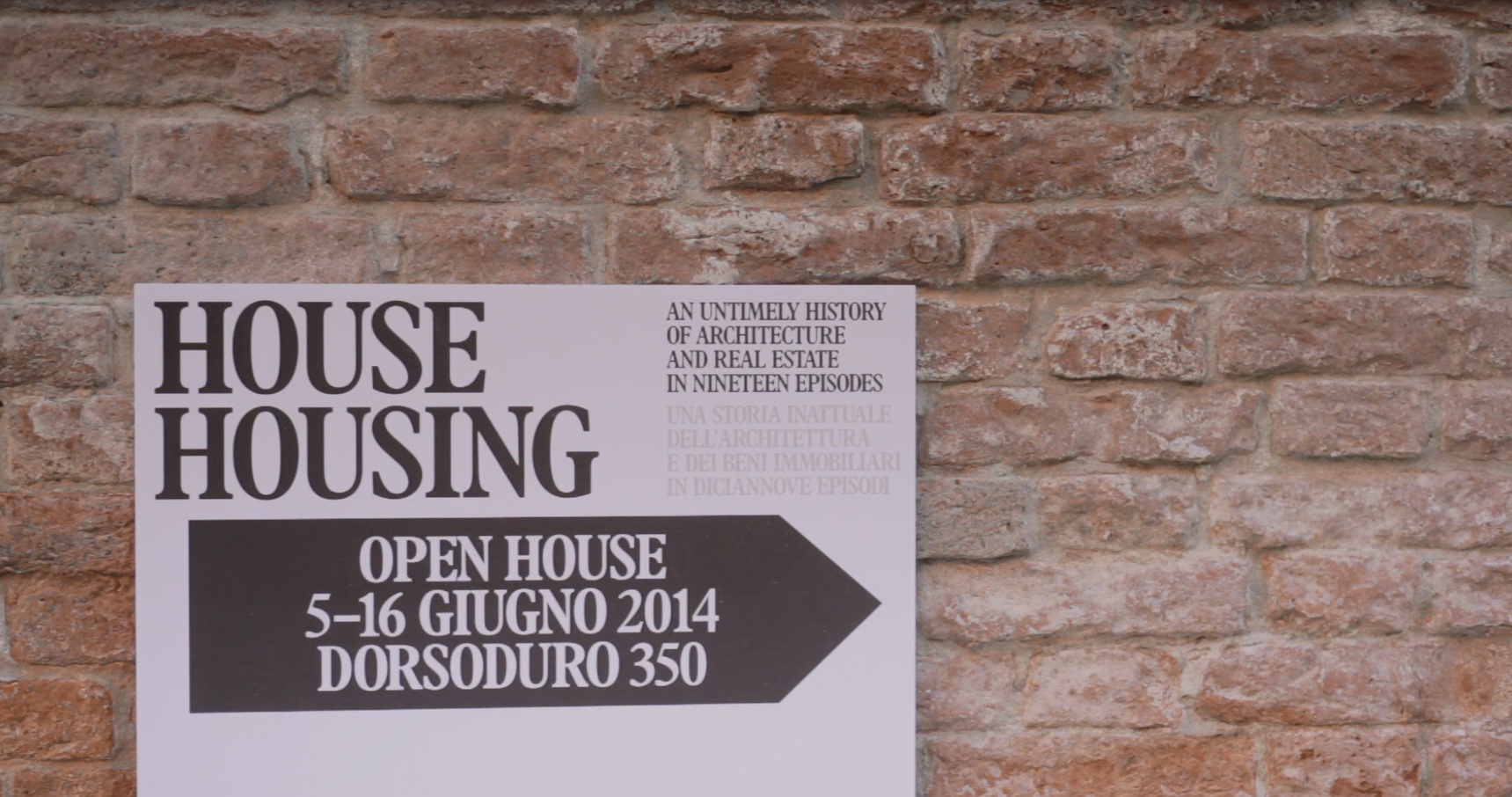 Event introduction poster placed in front of a brick wall