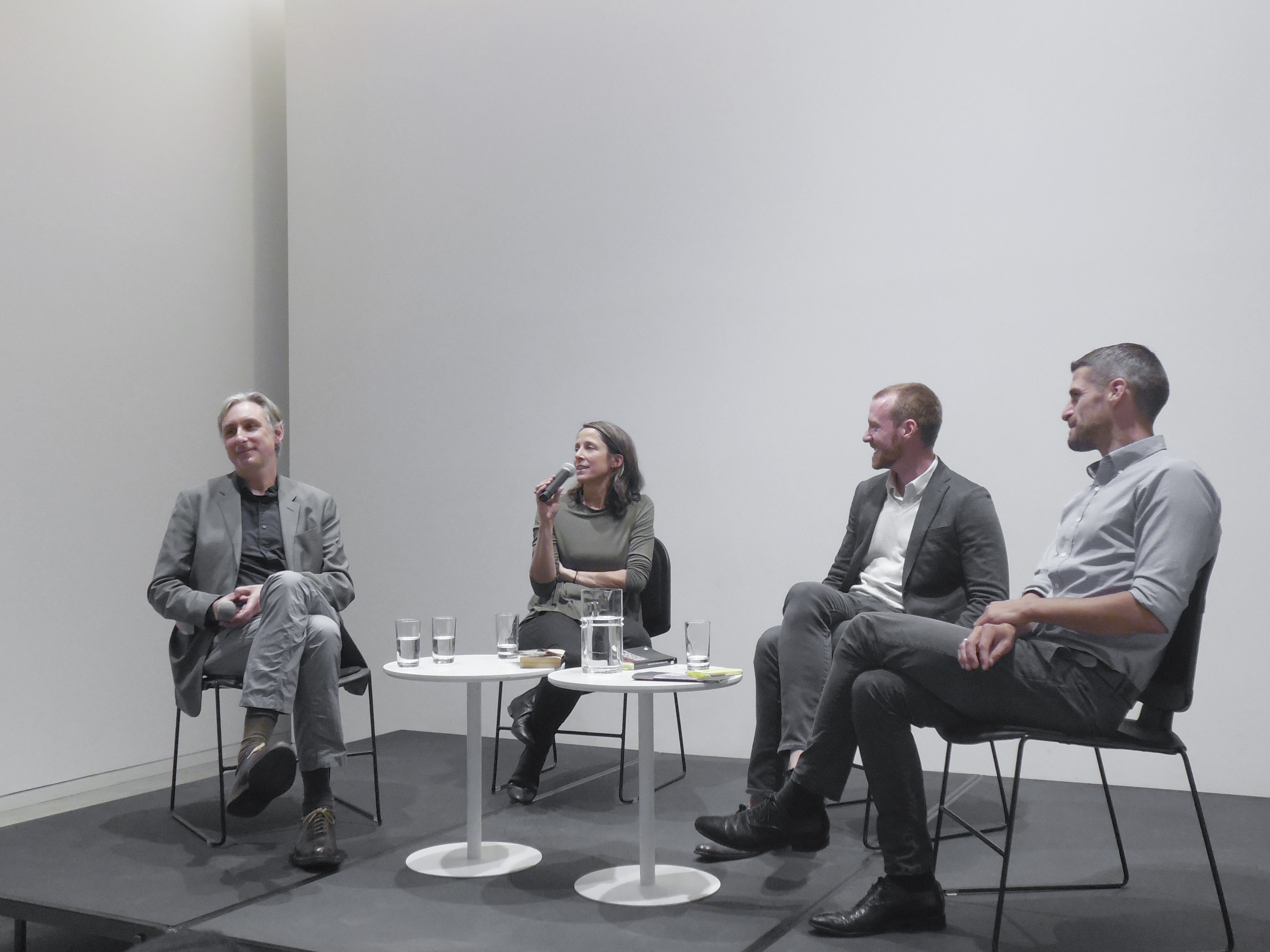 Four panelists seated at the front of the auditorium