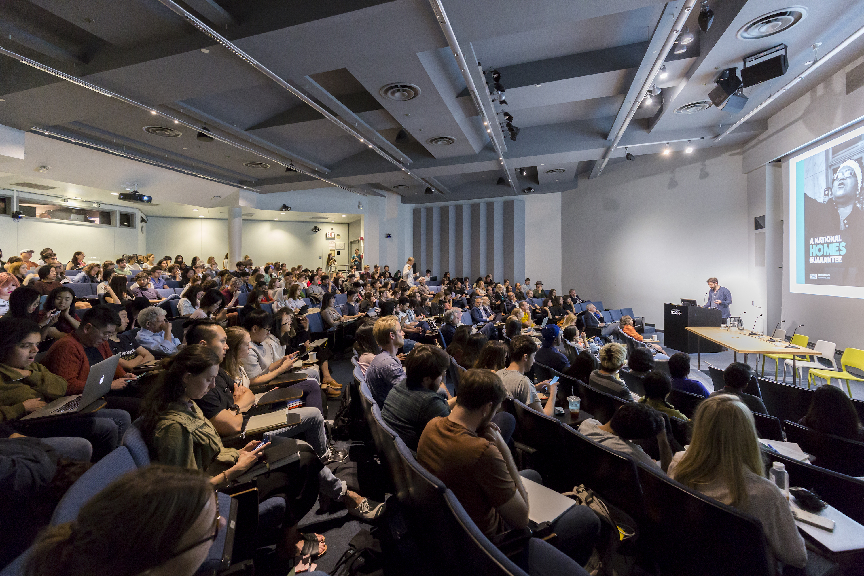 View of audience at Wood Auditorium during a presentation at "Public Works for a Green New Deal."