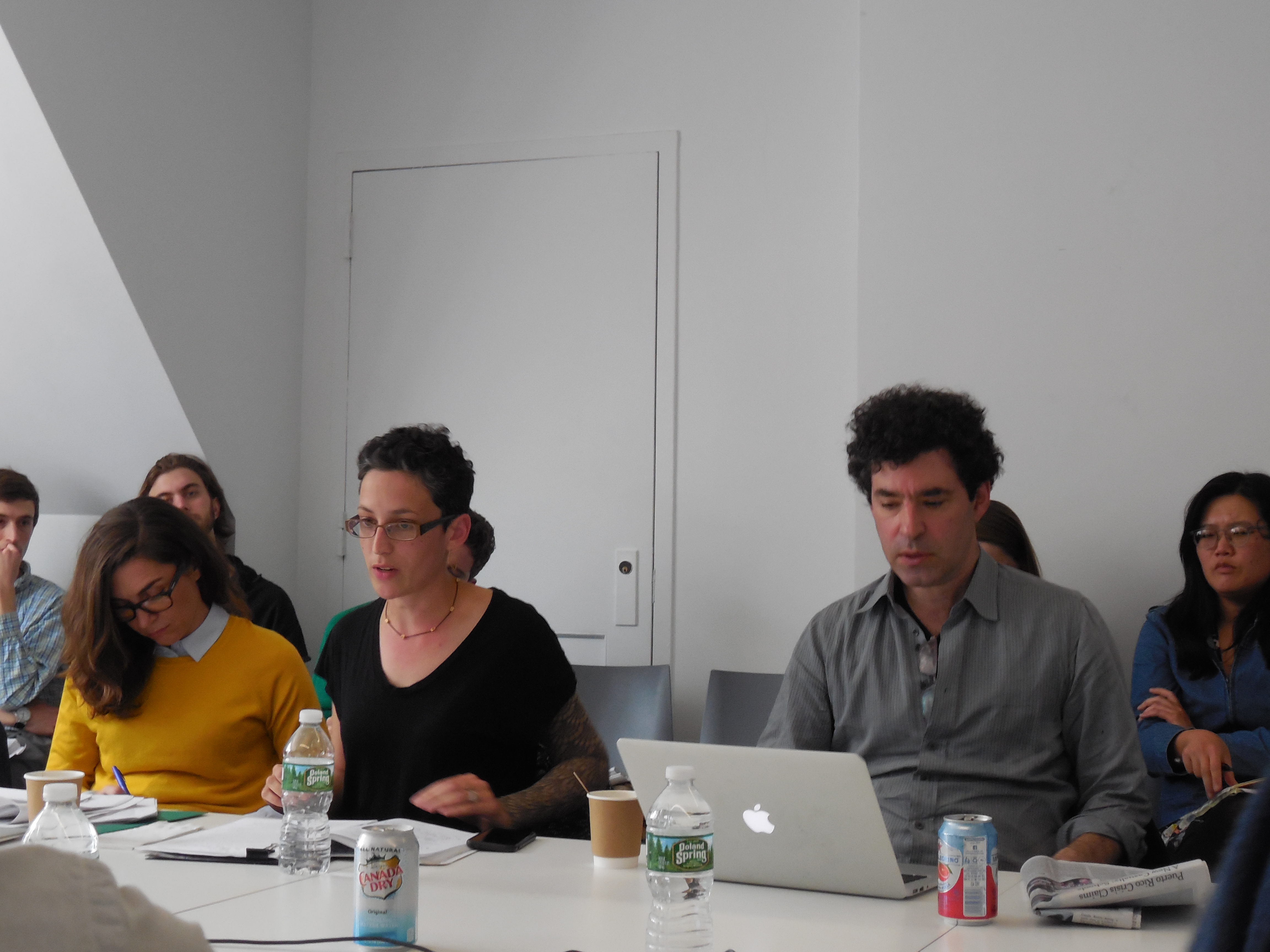 One person speaking and the others listening while seated at a conference table
