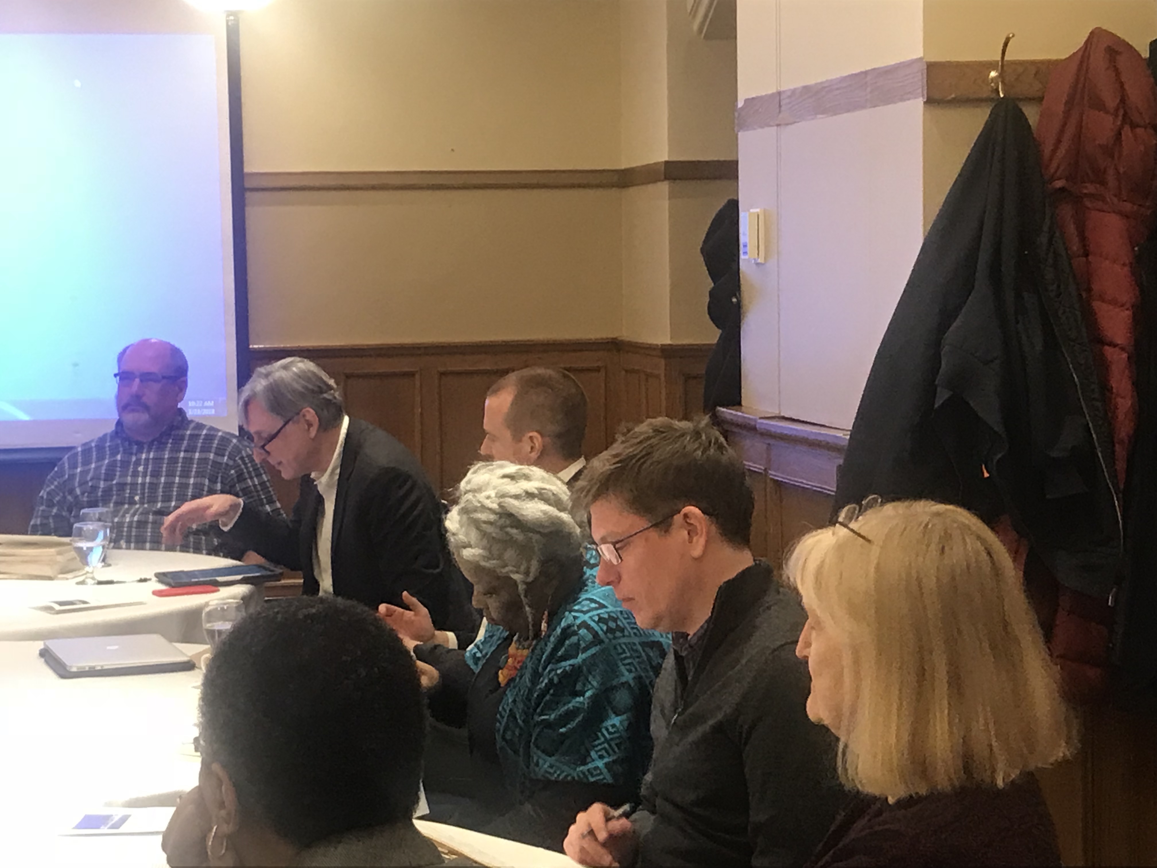 Listeners seated at the long table for the conference